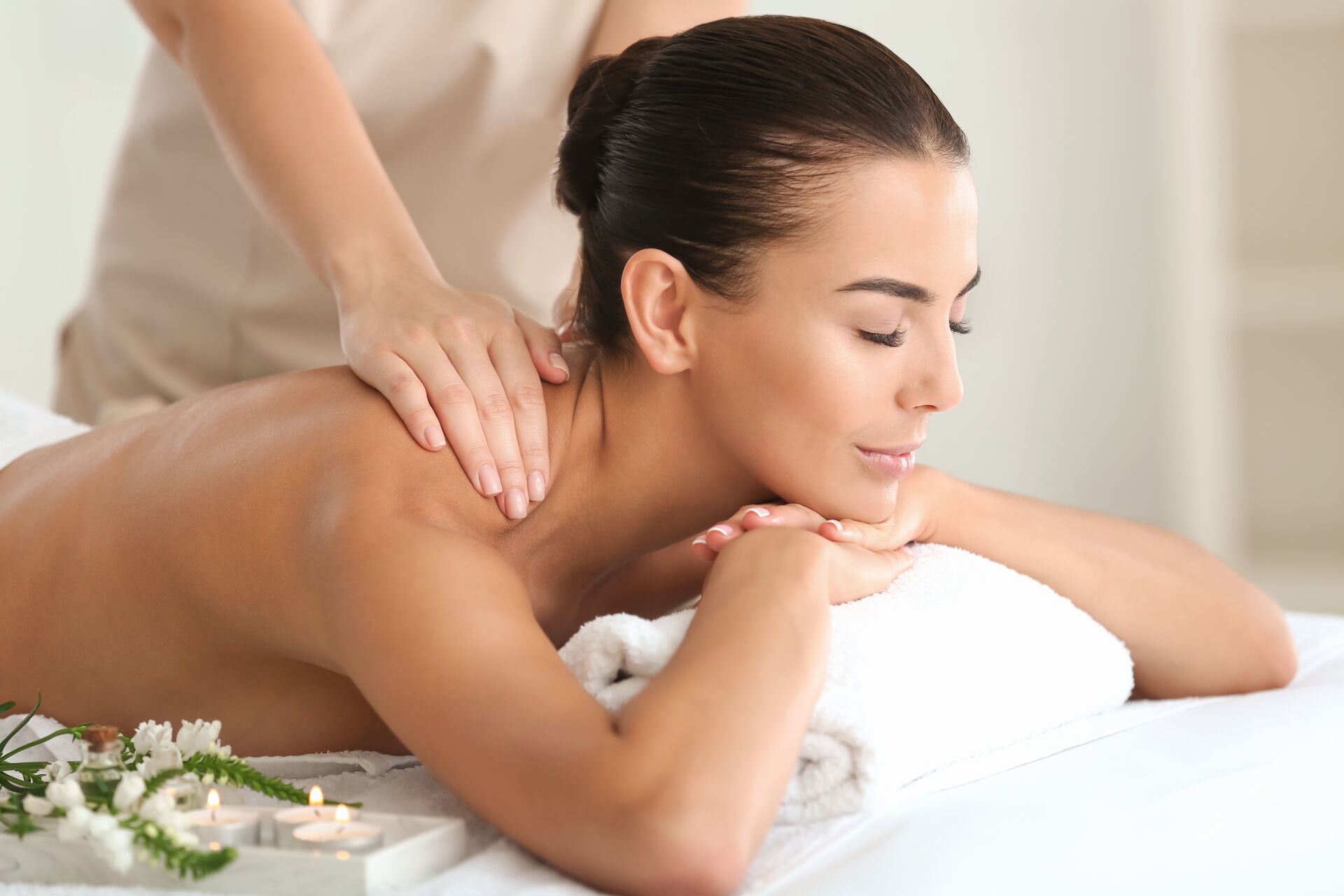  Aromatherapie-Zubehör mit Ölen, Blüten und Kerzen in entspannter Atmosphäre