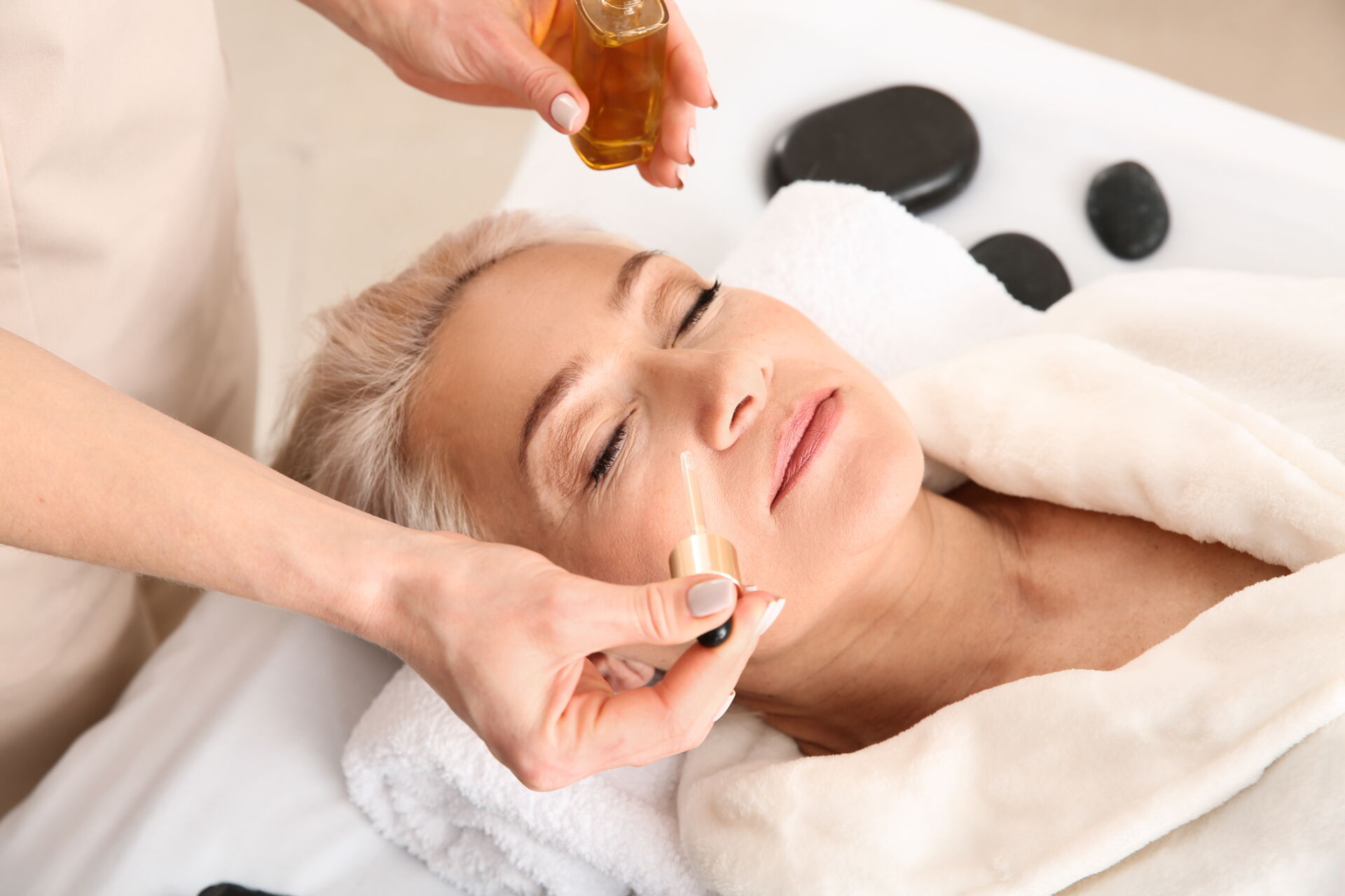  Kosmetikbehandlung mit Pinsel und Maske im Gesicht